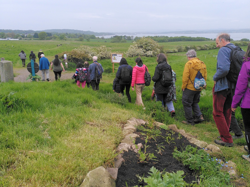 A line of people set off walking across the farm