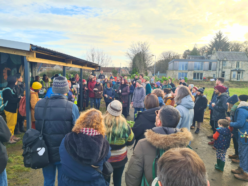 Large crowd of people gathered in the farmyard for an event